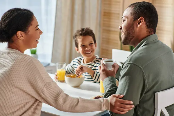 Concentrarsi sulla coppia afro-americana guardando amorevolmente l'un l'altro con il loro figlio offuscato sullo sfondo — Foto stock