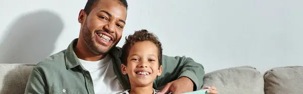 Allegro afroamericano padre e figlio in casalinghi casalinghi sorridendo gioiosamente alla macchina fotografica, banner — Foto stock