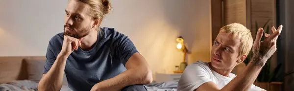 Gay man talking to upset and offended love partner sitting at night in bedroom, banner — Stock Photo