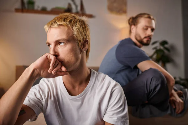 Offended gay couple sitting in silence in bedroom at night, troubled love and misunderstanding — Stock Photo