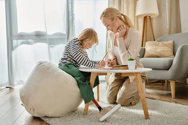 Mother and child with prosthetic leg drawing on paper with colorful pencils together, quality time — Stock Photo
