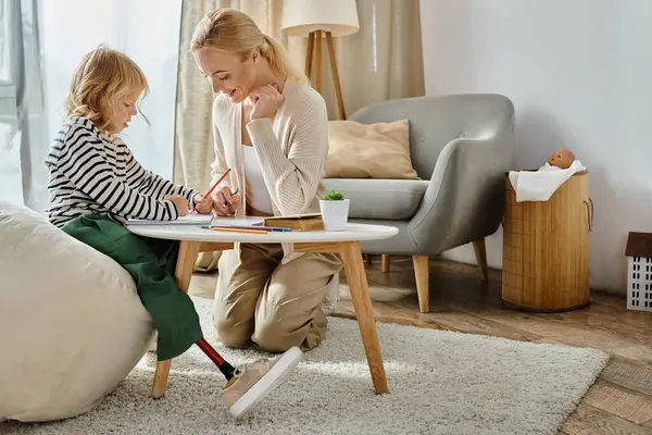 Woman and girl with prosthetic leg drawing on paper with colorful pencils together, quality time — Stock Photo