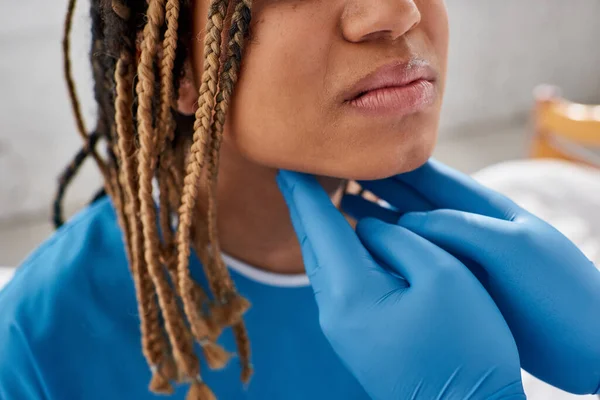 Vista ritagliata del medico indiano esaminando linfonodi del suo malato afro-americano paziente femminile — Foto stock