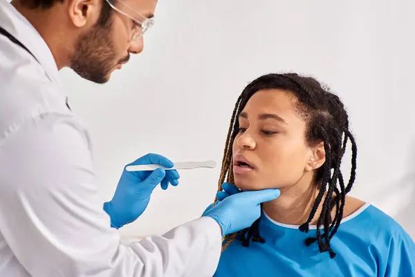 Jeune femme afro-américaine malade en salle d'hôpital ayant un médecin vérifier la gorge, les soins de santé — Photo de stock