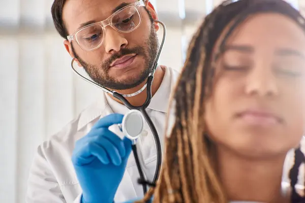 Focus on doctor checking breath of his blurred african american patient in hospital ward, healthcare — Stock Photo