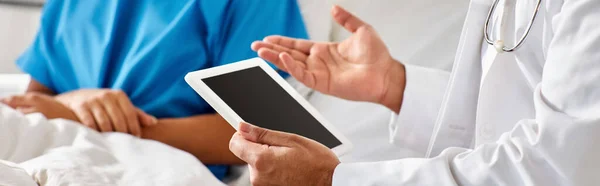 Cropped view of african american woman in hospital bed next to indian doctor holding tablet, banner — Stock Photo