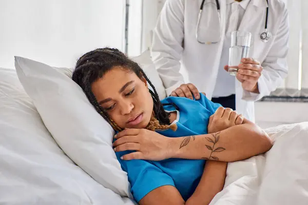 Vista recortada del médico indio consolando a su paciente afro-americano enfermo, salud - foto de stock