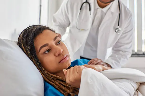 Vista ritagliata del medico indiano confortando il suo malato triste paziente afroamericano donna, assistenza sanitaria — Foto stock