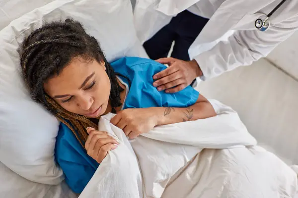 Cropped view of indian doctor comforting his ill sad african american female patient, healthcare — Stock Photo