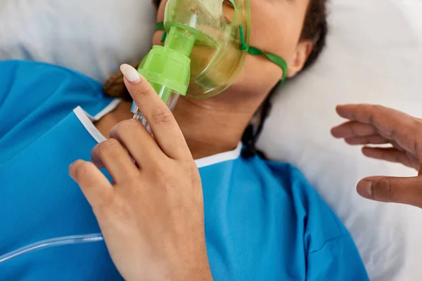 Vista ritagliata del medico confortante donna afro-americana sdraiata in letto d'ospedale con maschera di ossigeno — Foto stock