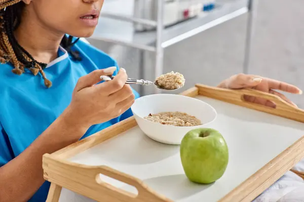Vista ritagliata di giovane donna afroamericana che fa colazione in letto d'ospedale, assistenza sanitaria — Stock Photo