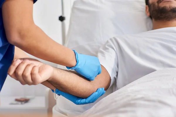 Cropped view of african american nurse inserting catheter into arm of her indian patient, healthcare — Stock Photo