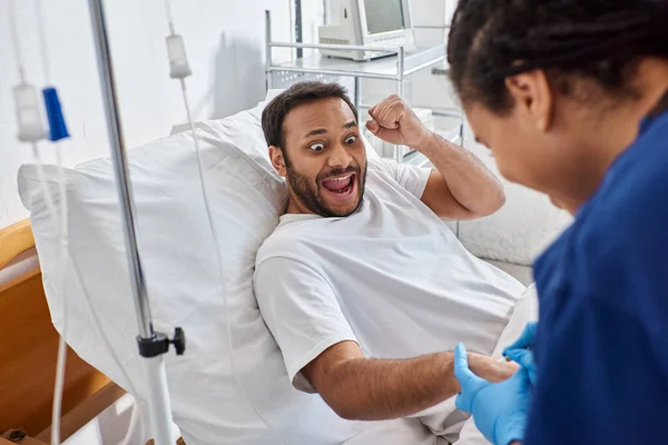 Giovane infermiera afroamericana che inserisce il catetere nel braccio della sua paziente indiana malata, assistenza sanitaria — Foto stock