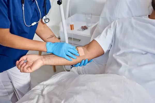 Cropped view of african american nurse inserting catheter into arm of her indian patient, healthcare — Stock Photo
