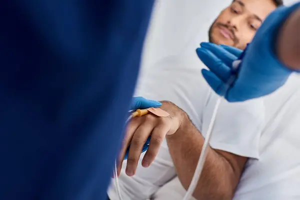 Vista ritagliata dell'infermiera afroamericana che inserisce il catetere nel braccio del suo paziente indiano, assistenza sanitaria — Foto stock