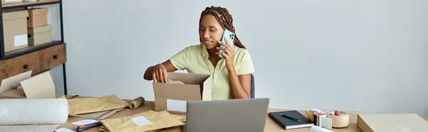 Счастливая африканская американская продавщица говорит по телефону и упаковке коробки, концепции доставки, баннер — стоковое фото