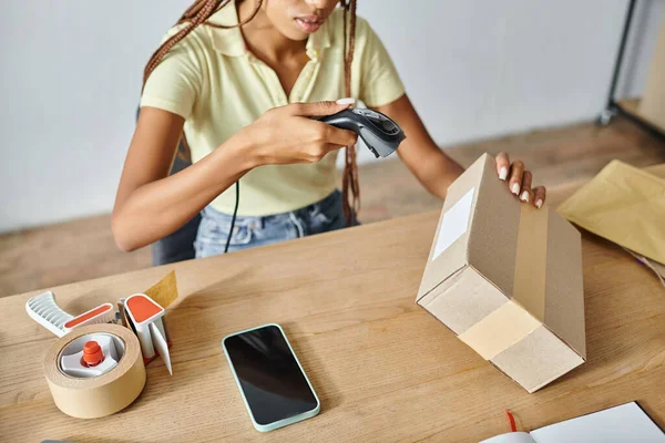 Cropped view of hard working african american female seller scanning box, delivery concept — Stock Photo