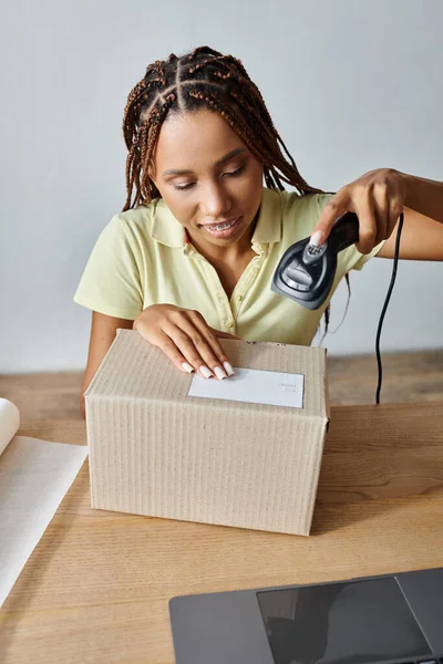 Хорошо выглядящие трудолюбивые африканские американка торговец сканирования картонная коробка, концепция доставки — стоковое фото