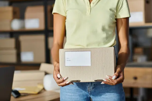 Vue recadrée de la jeune femme afro-américaine tenant boîte avec des écrits pendant le travail, livraison — Photo de stock