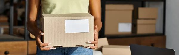Cropped view of happy african american woman with box in hands while working hard, delivery, banner — Stock Photo