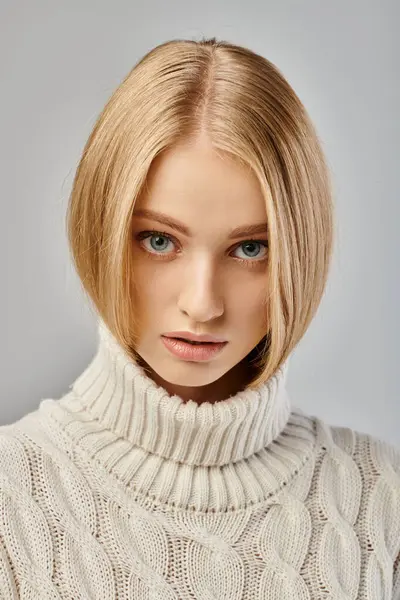 Portrait de charmante femme blonde avec maquillage naturel et regard expressif regardant caméra sur gris — Photo de stock
