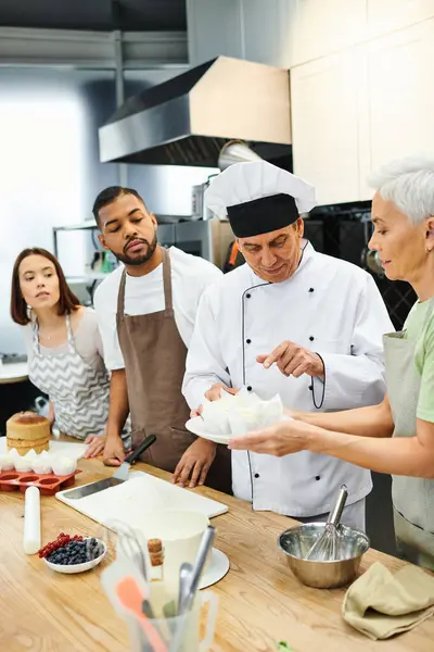 Handsome concentrated chef in white hat explaining how to bake to diverse students, confectionary — Stock Photo