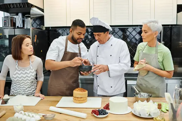 Alunos multiculturais atraentes em aventais aprender a assar com chef maduro, cursos de culinária — Fotografia de Stock