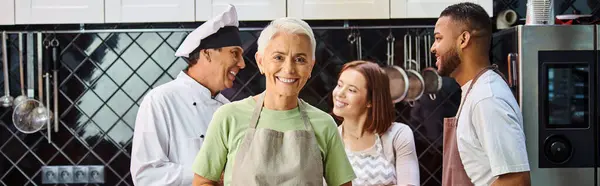 Focus on woman with cake smiling at camera with blurred diverse friends and chef on backdrop, banner — Stock Photo