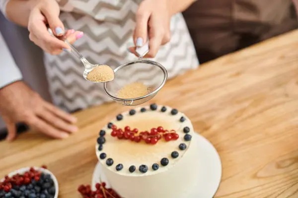 Mujer joven con esmalte de uñas decorando delicioso pastel al lado del chef, mientras que en la lección de cocina - foto de stock