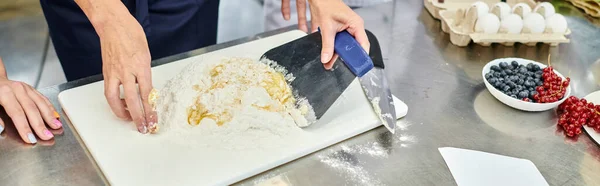 Vue recadrée de femme mature travaillant avec de la pâte à côté du chef cuisinier et ses collègues, bannière — Photo de stock