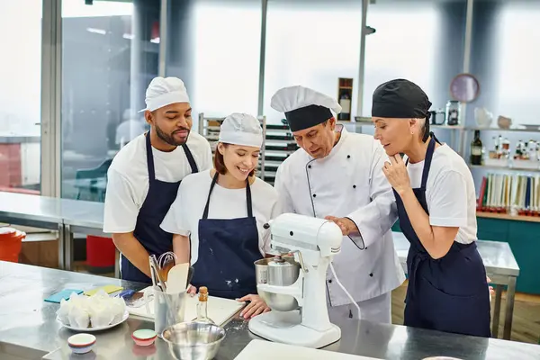 Good looking cheerful diverse chefs working with their chief cook using mixer, confectionery — Stock Photo