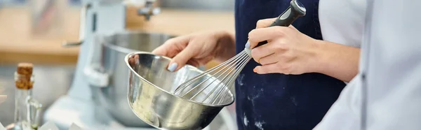 Cropped view of young female chef whisking ingredients next to chief cook, confectionery, banner — Stock Photo