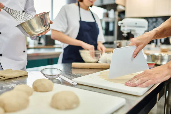 Vista ritagliata della pasta taglio chef femminile accanto al giovane collega e capo cuoco, pasticceria — Foto stock