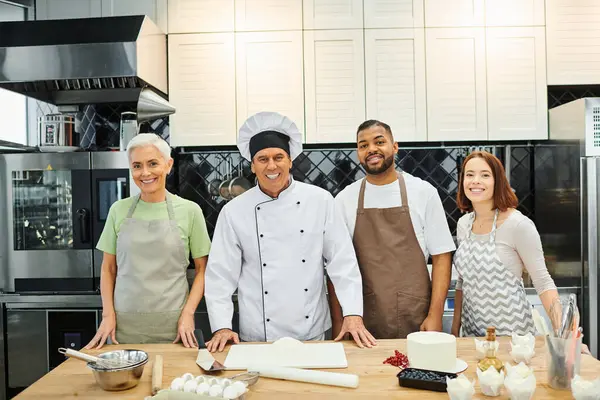 Joyful multiracial students next to mature chef during lesson smiling at camera, cooking courses — Stock Photo