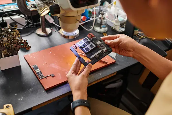 Erfahrene Spezialisten halten Mikro-Schema während der Arbeit in Reparaturwerkstatt, Kleinunternehmen — Stockfoto