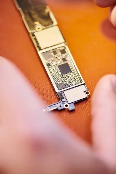 Крупный план микросхемы рядом с обрезанным техником в мастерской, бизнес по ремонту электроники — стоковое фото