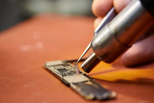 Cropped view of skilled technician assembling microscheme of electronic gadget in repair shop — Stock Photo