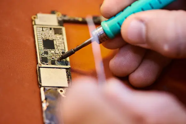 Partial view of technician soldering microscheme of electronic device in workshop, close up view — Stock Photo