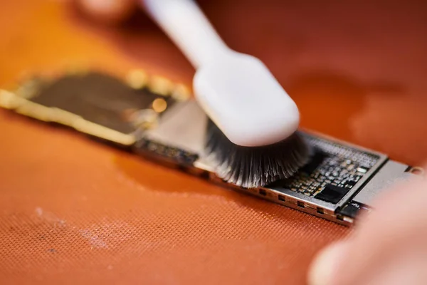 Visão recortada de técnico de limpeza de microesquema eletrônico com escova em oficina profissional — Fotografia de Stock