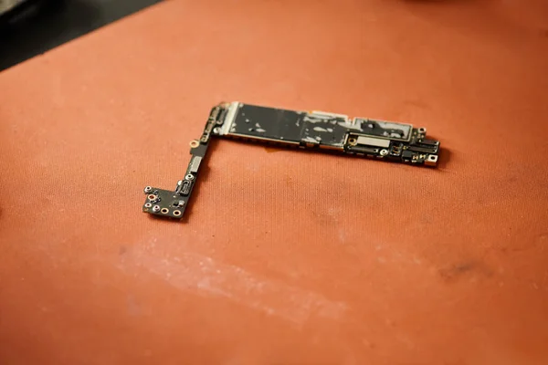 Microesquema electrónico de dispositivo electrónico roto en la mesa en taller de reparación, pequeña empresa - foto de stock