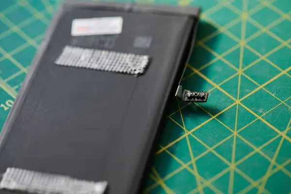 Крупный план батареи мобильного телефона на столе в ремонтной мастерской, бизнес по обслуживанию электроники — стоковое фото