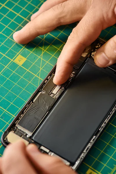 Cropped view of professional repairman assembling repaired mobile phone in workshop, small business — Stock Photo
