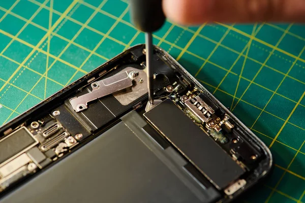 Cropped view of skilled repairman assembling repaired smartphone in workshop, small business — Stock Photo