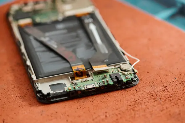 Крупним планом вид розібраного розбитого смартфона на столі в майстерні по ремонту обладнання, обслуговування — стокове фото