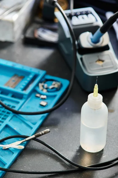 Plastic bottle and professional testing equipment on table in repair shop, maintenance service — Stock Photo