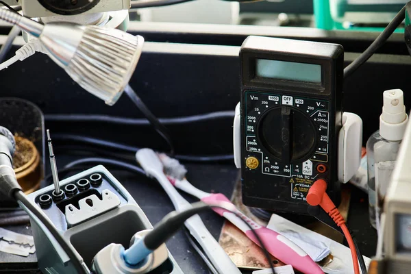 Voltmetro e varie attrezzature e strumenti sul tavolo in officina di riparazione, attività di servizi di manutenzione — Foto stock