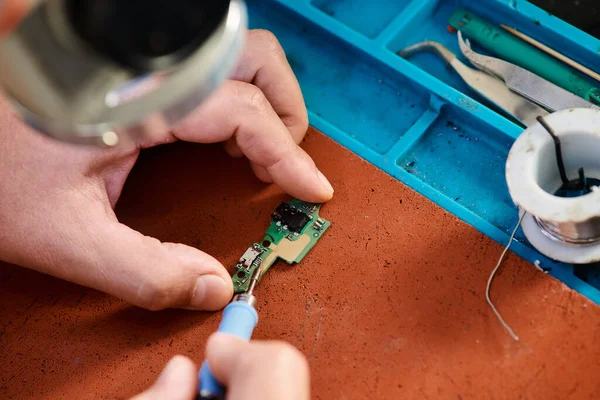 Cropped view of technical specialist soldering microscheme in repair shop, maintenance service — Stock Photo