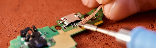 Close up of professional repairman soldering electronic chipset in workshop, horizontal banner — Stock Photo