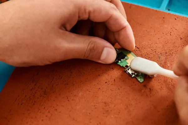 Обрізаний вид професійного ремонтанта чип з пензлем в майстерні, електронне обслуговування — стокове фото