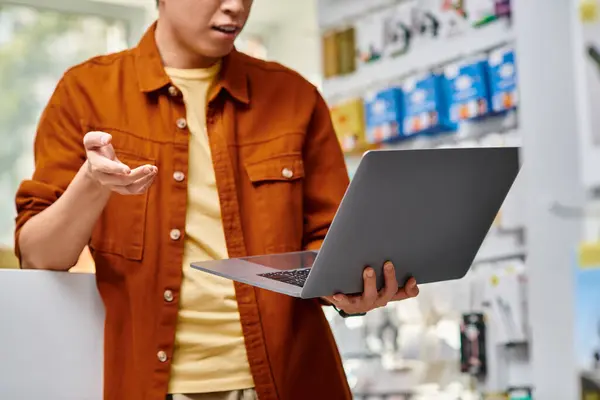 Обрізаний вид бізнесмена жестикулюючи під час відеодзвінка на ноутбуці в приватному магазині електроніки — стокове фото